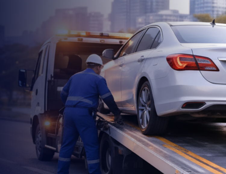 Tow truck loading a car on a road